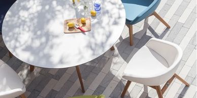 Sunlit outdoor table with modern chairs and refreshments.