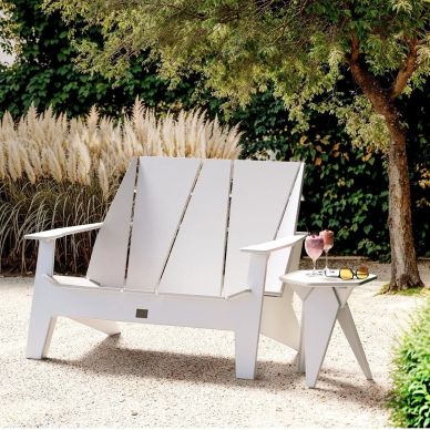 White wooden garden chair and side table with drinks outdoors.