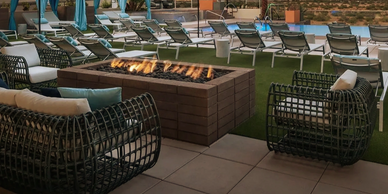 Cozy outdoor seating area with fire pit and lounge chairs.