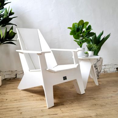 White modern chair near small table with potted plants.