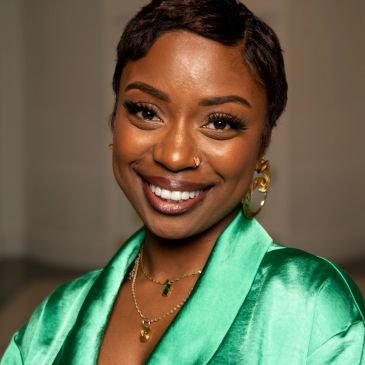 Smiling woman in a green satin outfit.