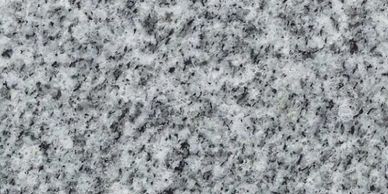 Close-up of gray granite stone texture with black and white speckles.