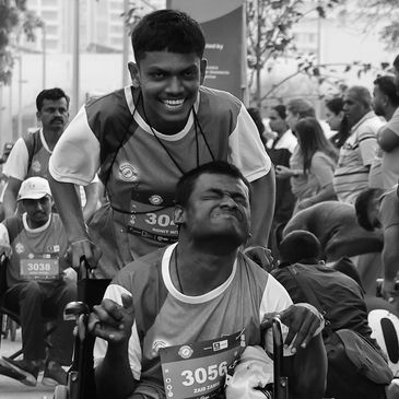 PWD athlete with ally pushing wheelchair during Run InSync, celebrating unity in sport.