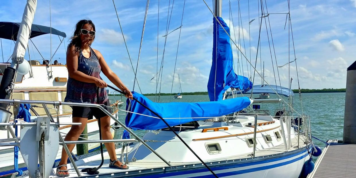 Guest holding dockline on deck of a 37ft Hunter sailboat, during private charter in Port Charlotte.