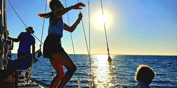 A family with children playing on the sailboat deck at sunset during a Charlotte Harbor cruise in Fl