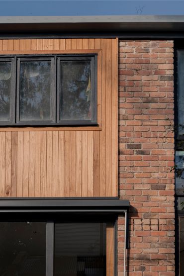Part of a modern house with wooden and brick exterior.
