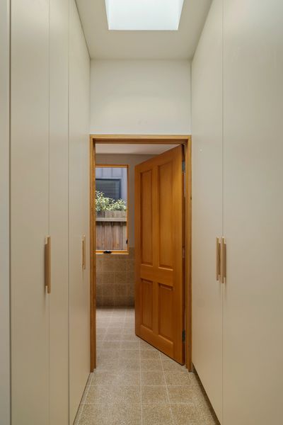 Custom cabinetry for concealed euro laundry with skylight above. Solid timber door to bathroom. 