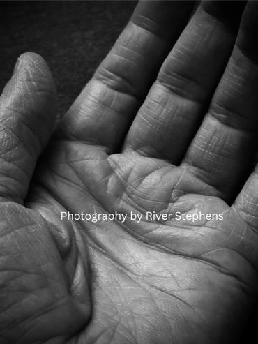 Close-up black and white photo of an open hand showing detailed lines and texture.