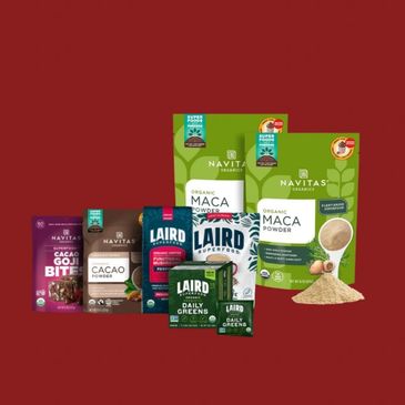 Various organic superfood powders and bites from Navitas and Laird on a maroon background.