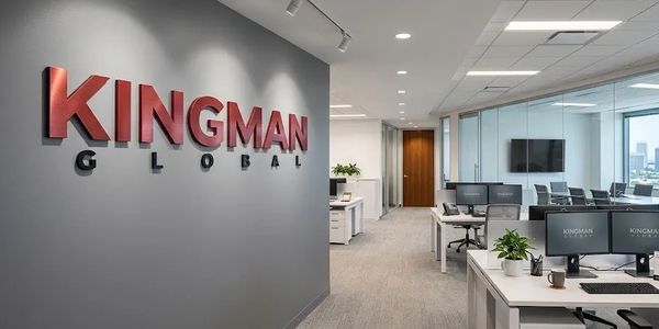 Modern office space with KINGMAN GLOBAL logo on the wall and multiple workstations.