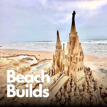 Intricate sandcastle with tall towers on a beach shore.