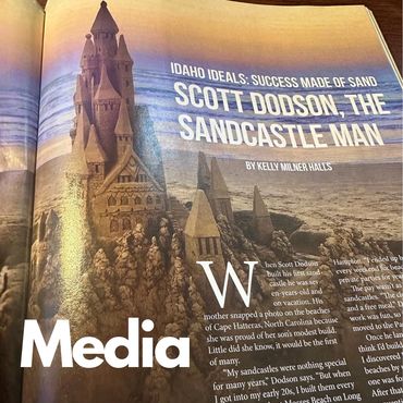 Elaborate sandcastle structures on a beach featured in a magazine article.