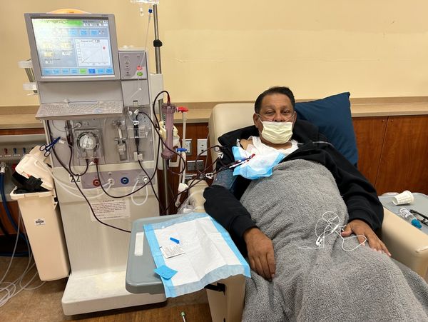 A man undergoing dialysis treatment connected to a medical machine.