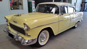 Vintage yellow and white classic car in a garage.