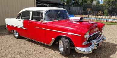 Classic red and white vintage car parked outdoors.
