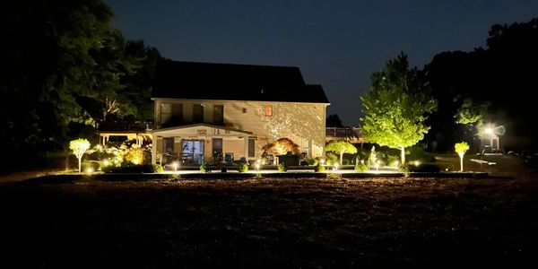 A house illuminated with garden lights at night.