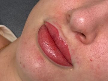 Close-up of lips with red lipstick.