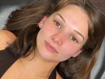 Young woman lying down with natural makeup and clear skin.