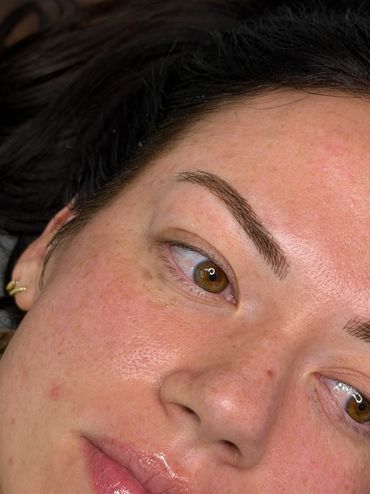 Close-up of a woman's face showing natural skin texture and freckles.
