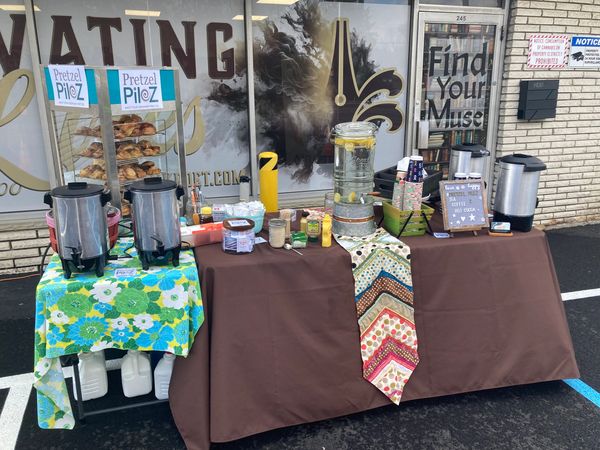 Outdoor beverage station with coffee, tea, and water setup.