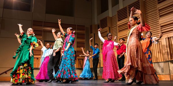 A group performing traditional flamenco dance in colorful dresses.
