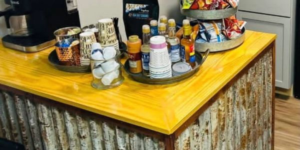 Rustic snack and coffee station on a wooden counter.