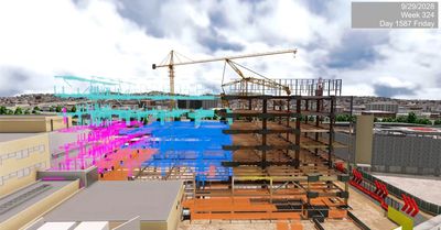 Construction site with cranes and a digital overlay of building plans.