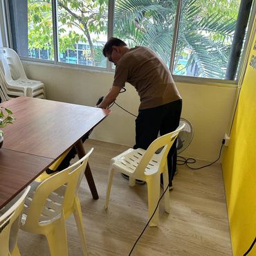 Man working on electrical wiring in a bright room.