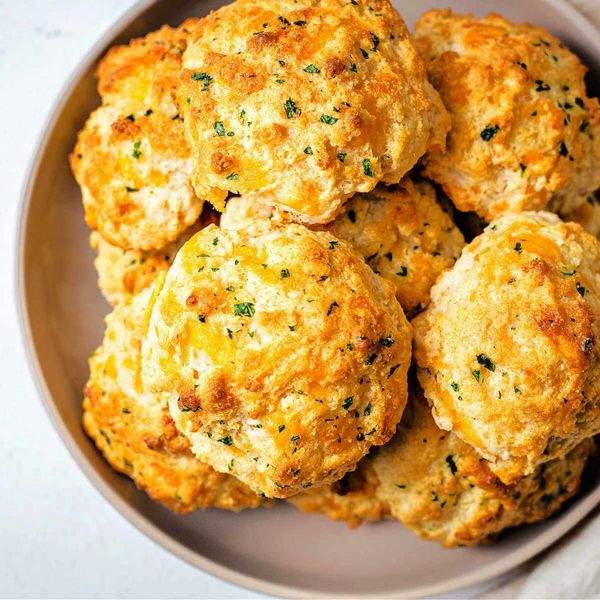 Golden, cheesy biscuits with herbs, served on a plate.