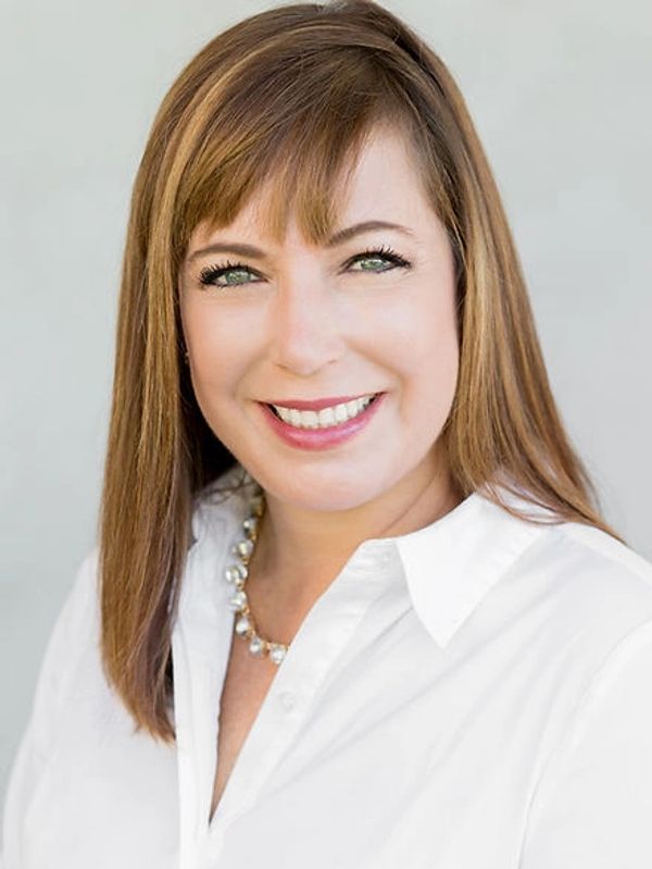 Woman with light brown hair smiling. 