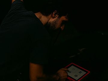 Technician diagnosing no-start and driveability issues using a diagnostic tablet.