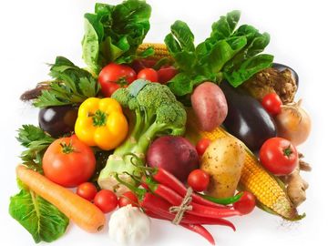 A vibrant assortment of fresh vegetables including tomatoes, peppers, broccoli, and corn.
