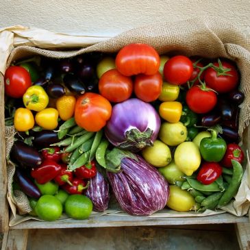 A colorful assortment of fresh vegetables in a burlap-lined basket.