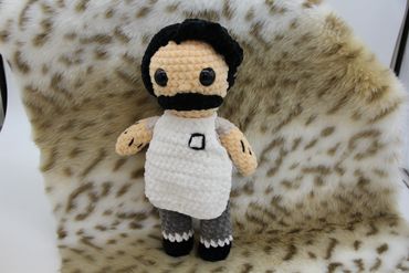 Crocheted doll resembling a man with a mustache and white apron.