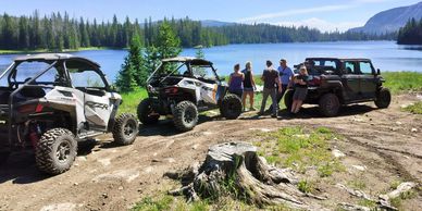Group enjoying an outdoor lakeside adventure with off-road vehicles.