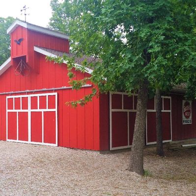 Red barn surrounded by trees.