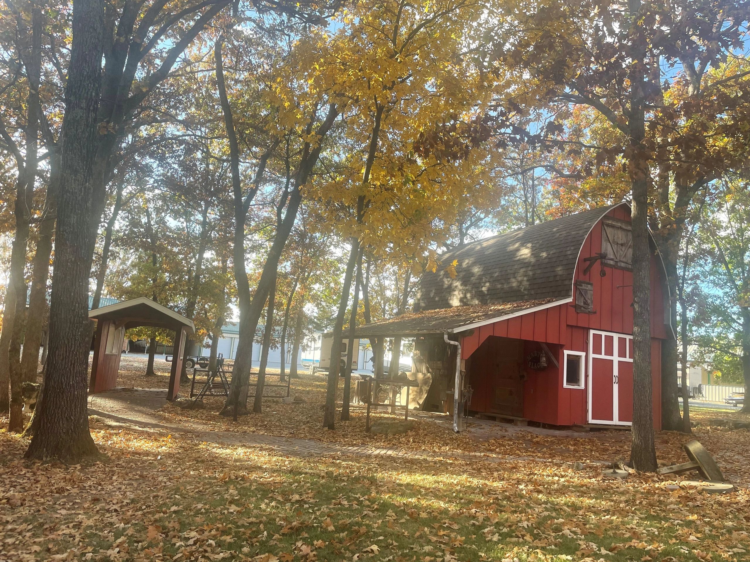 Autumn scene with red barn and yellow-leaved trees.