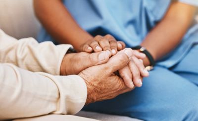 Two people holding hands as a gesture of support.
