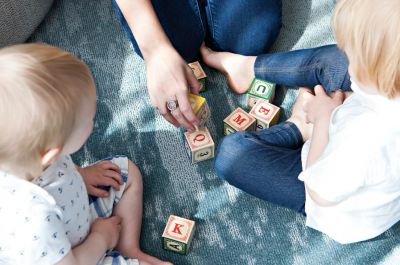 Two children playing with alphabet blocks.