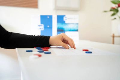 Hand moving game pieces on a table.