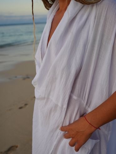 Woman in white dress on the beach.