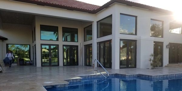 Modern house with large windows and a blue swimming pool.