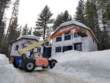 Construction of houses in a snowy forest.