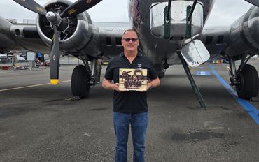 Bill holding a photo of his father-in-law Robert Sharp and his crew - 1945.