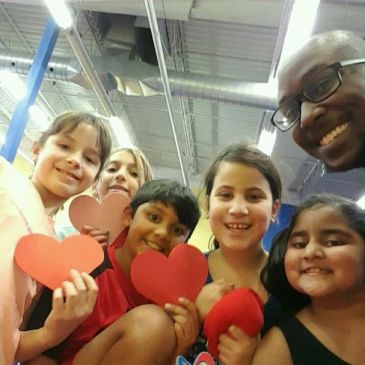 Happy group holding red heart shapes.