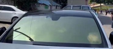 Car windshield covered with a yellowish substance obscuring visibility.