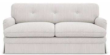 A striped fabric sofa with a skirt and button-tufted backrest.