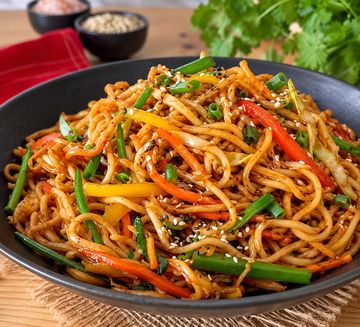 Stir-fried noodles with colorful vegetables and sesame seeds.