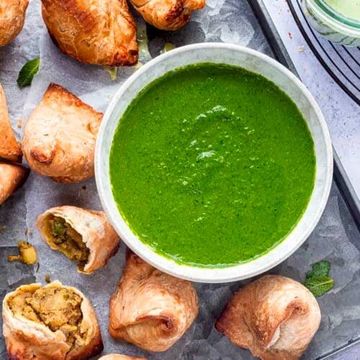 Green chutney with samosas on the side.