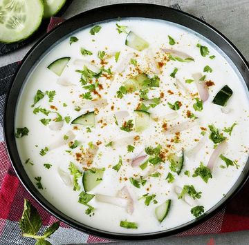 Bowl of yogurt cucumber salad with herbs.